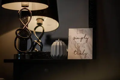 a table with a candle and a sign on a lamp at Liverpool Harrow Road Sleeps 6- Infinity Apartment in Liverpool