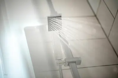 a shower in a white tiled bathroom at Liverpool Harrow Road Sleeps 6- Infinity Apartment in Liverpool