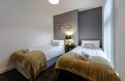 a bedroom with two beds with towels on them at Liverpool Harrow Road Sleeps 6- Infinity Apartment in Liverpool