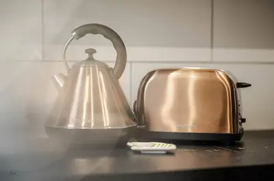 a tea kettle on a counter next to a toaster at Liverpool Harrow Road Sleeps 6- Infinity Apartment in Liverpool