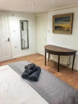 a room with a table and a rug on the floor at Garden Apartment in Grange Over Sands