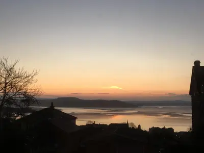 a sunset over a large body of water at Garden Apartment in Grange Over Sands