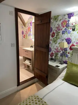a bedroom with a bed and a bathroom with a mirror at Low Fell in Ulverston