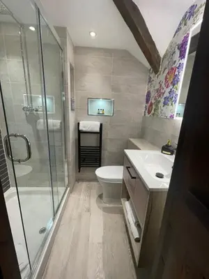 a bathroom with a shower and a toilet and a sink at Low Fell in Ulverston
