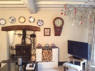 a living room with a clock and a tv at Low Fell in Ulverston