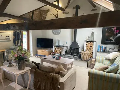 a living room with a couch and a table and a fireplace at Low Fell in Ulverston