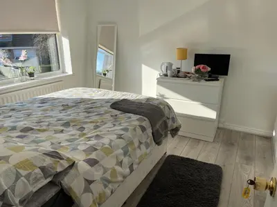 a bedroom with a bed and a dresser and a window at Chateau julie in Liverpool