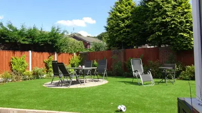a yard with chairs and a table in the grass at Chateau julie in Liverpool