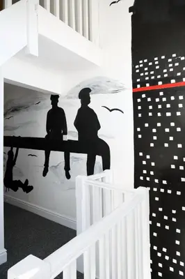 a wall mural of two men sitting on a bench at The Docklands Apartment by Serviced Living Liverpool in Liverpool