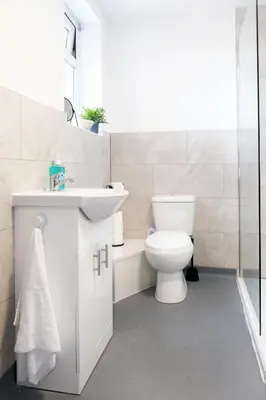 a white bathroom with a toilet and a sink at The Docklands Apartment by Serviced Living Liverpool in Liverpool