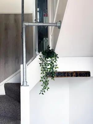a stairwell with a plant on the floor and a pipe at The Docklands Apartment by Serviced Living Liverpool in Liverpool