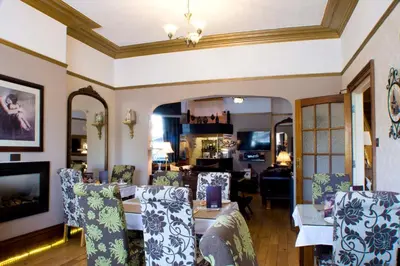 a living room with a dining table and chairs at The Leicester in Southport