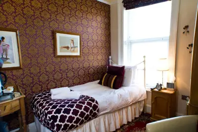 a bedroom with a bed in a room with a window at The Leicester in Southport