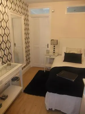 a bedroom with a bed and a tub and a sink at The Leicester in Southport