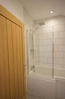 a bathroom with a tub and a shower and a shower backdoor at Stay in Blackpool
