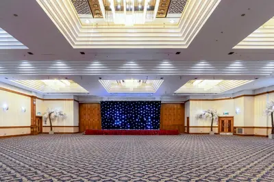an empty banquet hall with a stage in the middle at Grand Hotel Blackpool in Blackpool