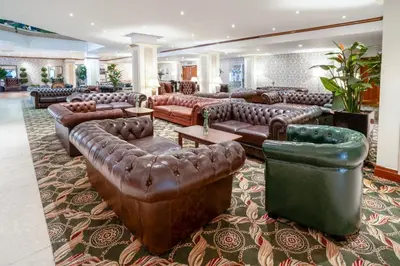 a large lobby with leather couches and tables at Grand Hotel Blackpool in Blackpool
