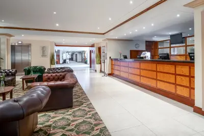 a lobby with leather couches and a bar at Grand Hotel Blackpool in Blackpool
