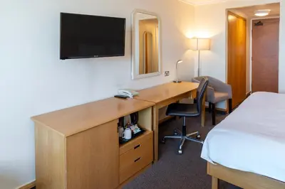 a hotel room with a desk with a tv and a bed at Grand Hotel Blackpool in Blackpool