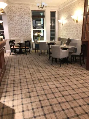 a restaurant with tables and chairs on a checkered floor at The Clarendon Hotel in Morecambe