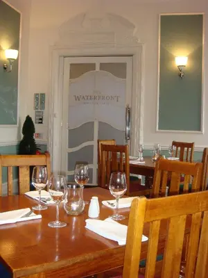 a dining room with a wooden table with wine glasses at The Clarendon Hotel in Morecambe