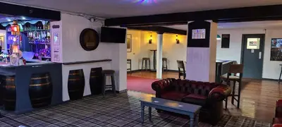 a bar with a leather couch and a bar counter at The Clarendon Hotel in Morecambe