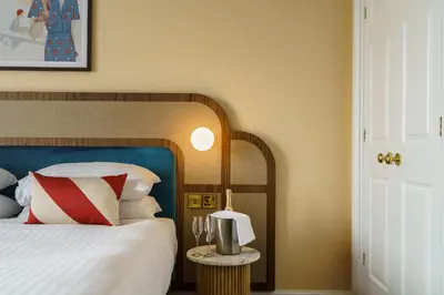 a bedroom with a bed with a blue headboard at Grange Hotel in Grange Over Sands
