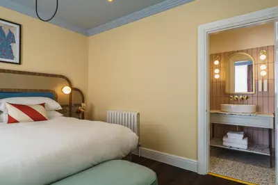 a bedroom with a bed and a mirror and a sink at Grange Hotel in Grange Over Sands