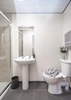 a white bathroom with a toilet and a sink at MARS Hotel Seaview Blackpool in Blackpool