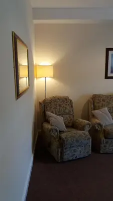 a living room with a chair and a lamp at delamere holiday apartments in Blackpool