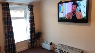 a television hanging on a wall in a room at delamere holiday apartments in Blackpool