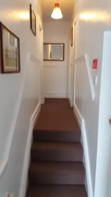 a staircase in a home with white walls and brown carpet at delamere holiday apartments in Blackpool