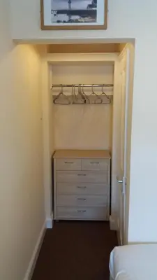 a bedroom with a closet with a dresser and a bed at delamere holiday apartments in Blackpool