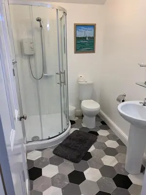 a bathroom with a shower and a toilet and a sink at delamere holiday apartments in Blackpool
