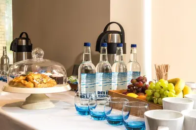 a table with bottles of wine and a tray of fruit at Holiday Inn Lancaster by IHG in Lancaster