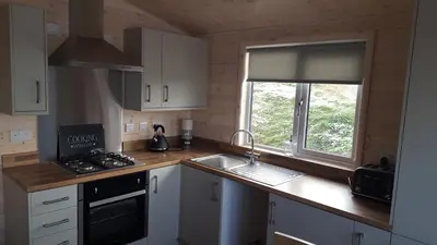 a kitchen with white cabinets and a sink and a window at Lunecliffe Country lodge-Lancaster Gateway to the Lakes in Lancaster