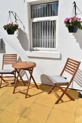 two chairs and a table next to a window at Adelaide Apartments in Blackpool