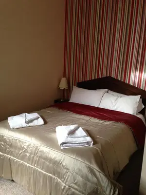 a bedroom with a bed with towels on it at Ambrose Hotel in Barrow in Furness