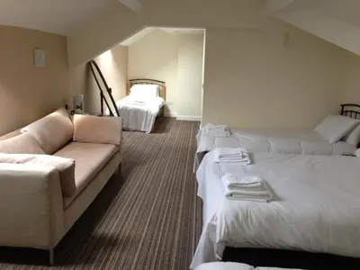a hotel room with two beds and a couch at Ambrose Hotel in Barrow in Furness