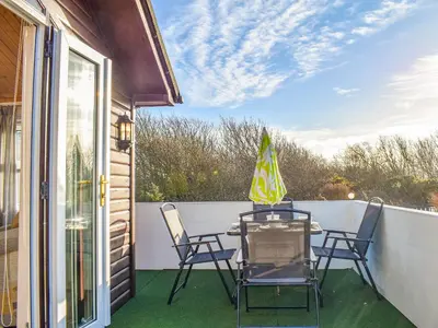 a patio with a table and chairs on a balcony at Tranquillity in Millom