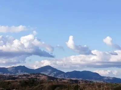 a blue sky with clouds and mountains in the background at Tranquillity in Millom