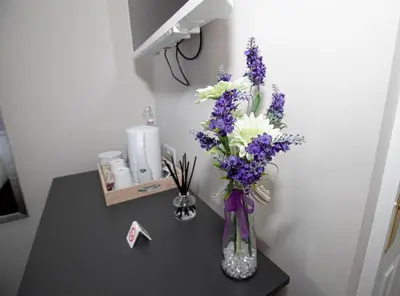 a vase filled with purple and white flowers on a table at Lynwood House in Southport
