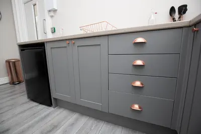 a gray kitchen with a counter and a sink at Lynwood House in Southport