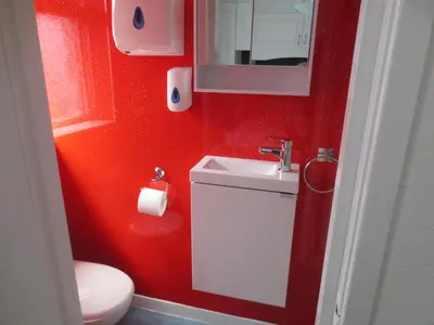 a red bathroom with a sink and a toilet at The Salendine in Blackpool