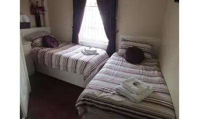 a bedroom with two beds with towels on them at The Salendine in Blackpool