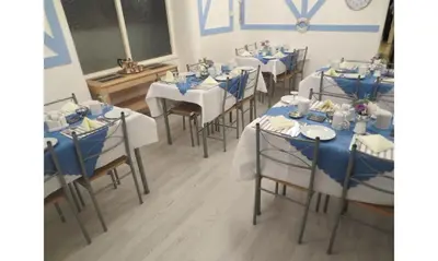a room with tables and chairs with blue and white tablecloths at The Salendine in Blackpool