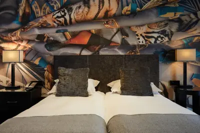 a bedroom with a bed with a mural on the wall at Malmaison Liverpool in Liverpool
