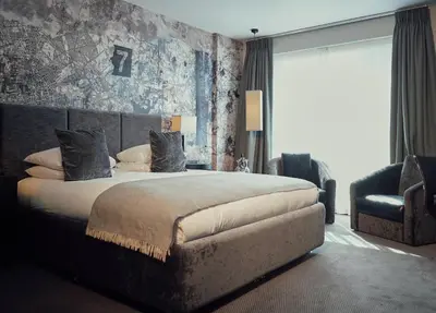 a bedroom with a large bed and a chair at Malmaison Liverpool in Liverpool
