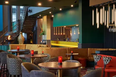 a restaurant with tables and chairs and a staircase at Malmaison Liverpool in Liverpool
