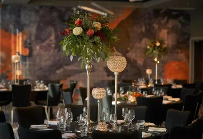 a dining room with tables and chairs with a flower arrangement at Malmaison Liverpool in Liverpool